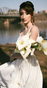 Bride holding calla lilies by the water with elegant bridal makeup by Waring Makeup, Ottawa Bridal Makeup Artist.