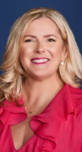 Corporate Event Makeup by Waring Makeup - Ottawa Professional Makeup Services Smiling woman in a red outfit with polished corporate event makeup, styled by Waring Makeup, Ottawa Corporate Makeup Artist.